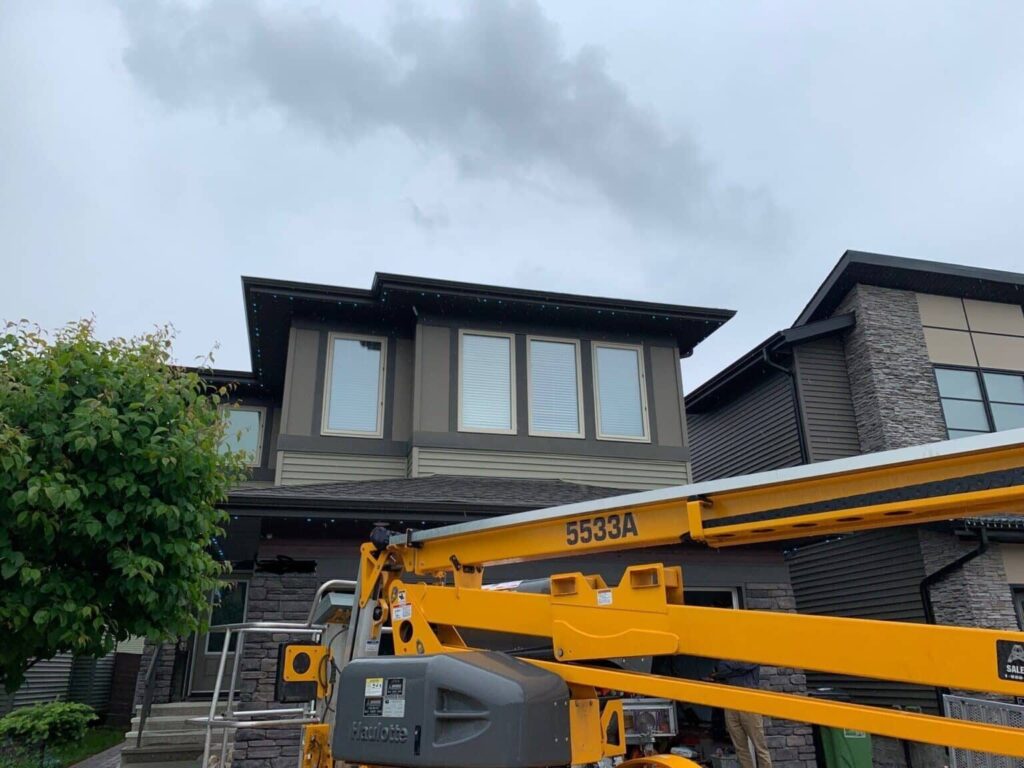 Large crane near a modern house under cloudy skies.