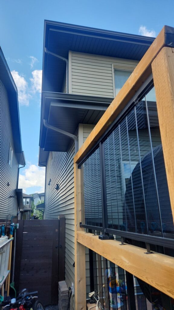 Depicts a tight space between two houses with a fence between them. It's nearly impossible to reach the second story to install permanent holiday lights safely.