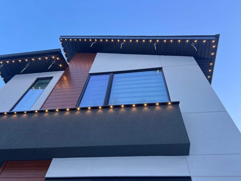 Modern house with string lights at dusk.