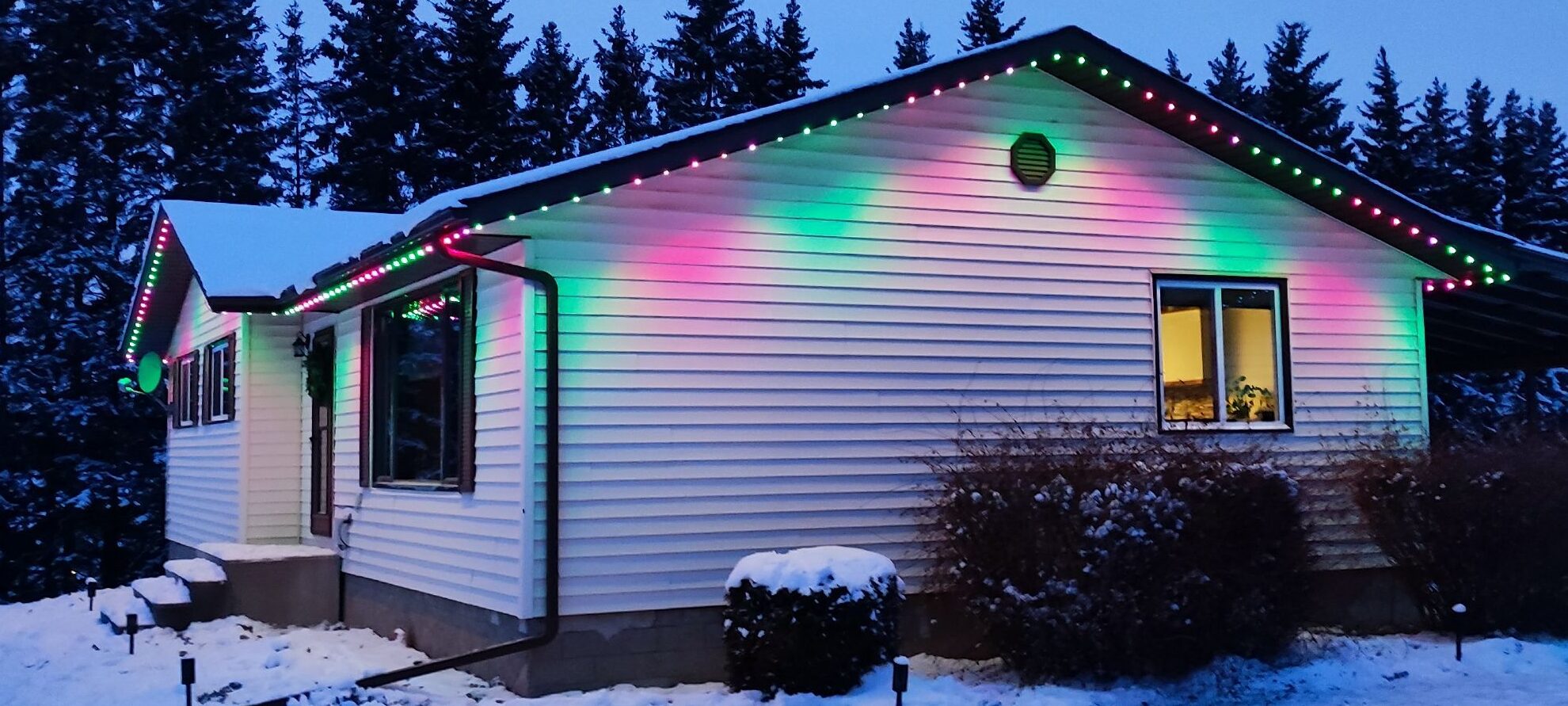 Watts Permanent Christmas Lights shining in Red and Green on two sides of a bungalow.