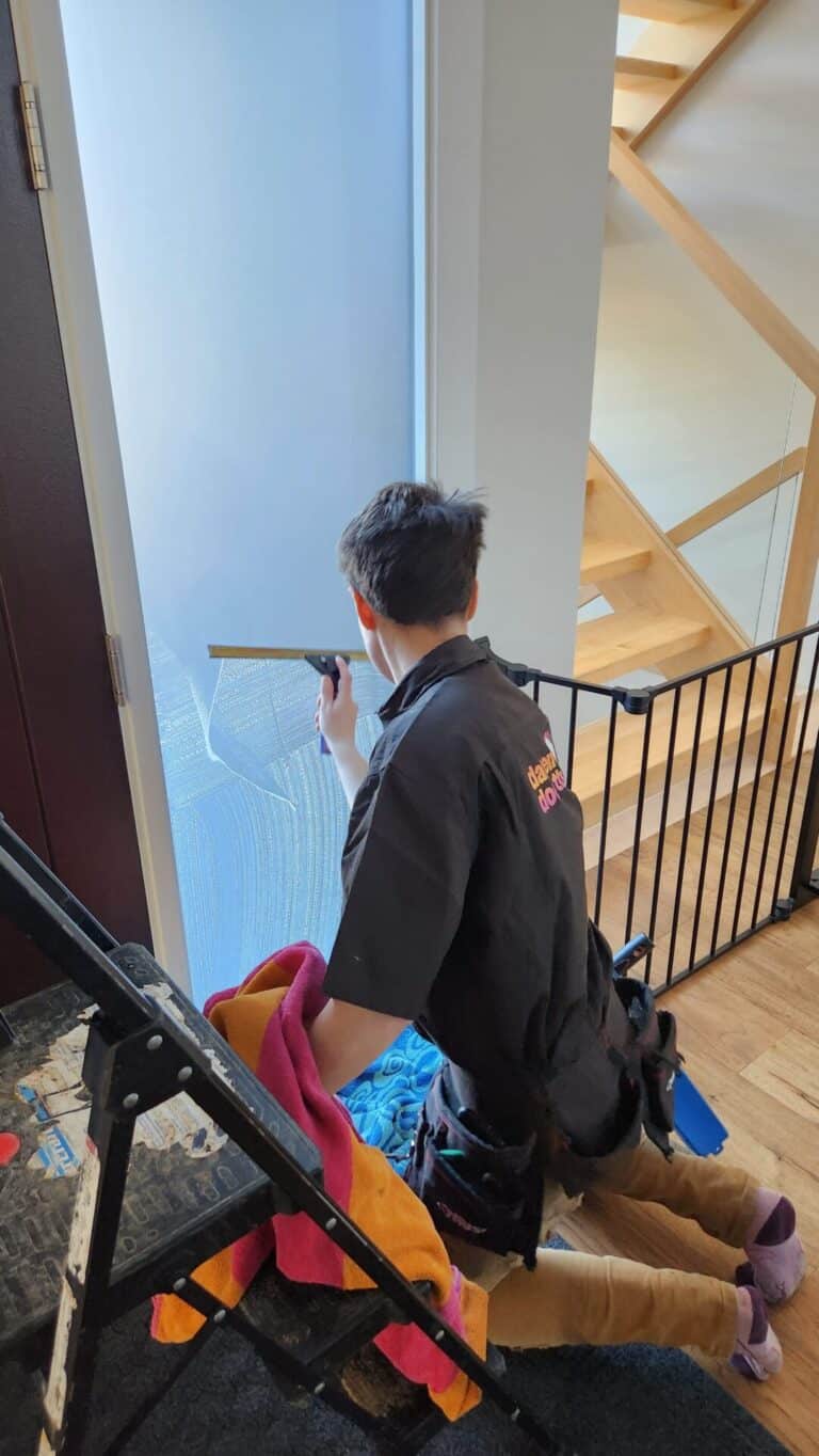 A Window Cleaner uses a squeegee on interior glass