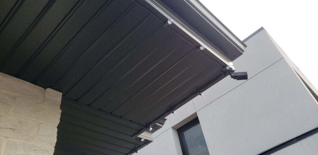 Commercial Grade Christmas Lights on black wire installed under the overhangs on a home with black soffit and fascia